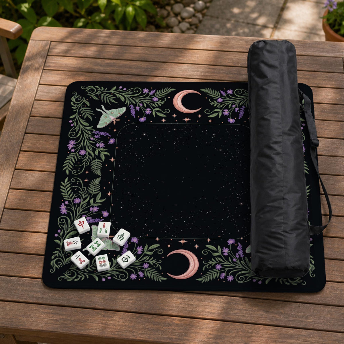 Black mahjong table mat with luna moths, purple flowers, soft green leaves, copper moons, and small star details.