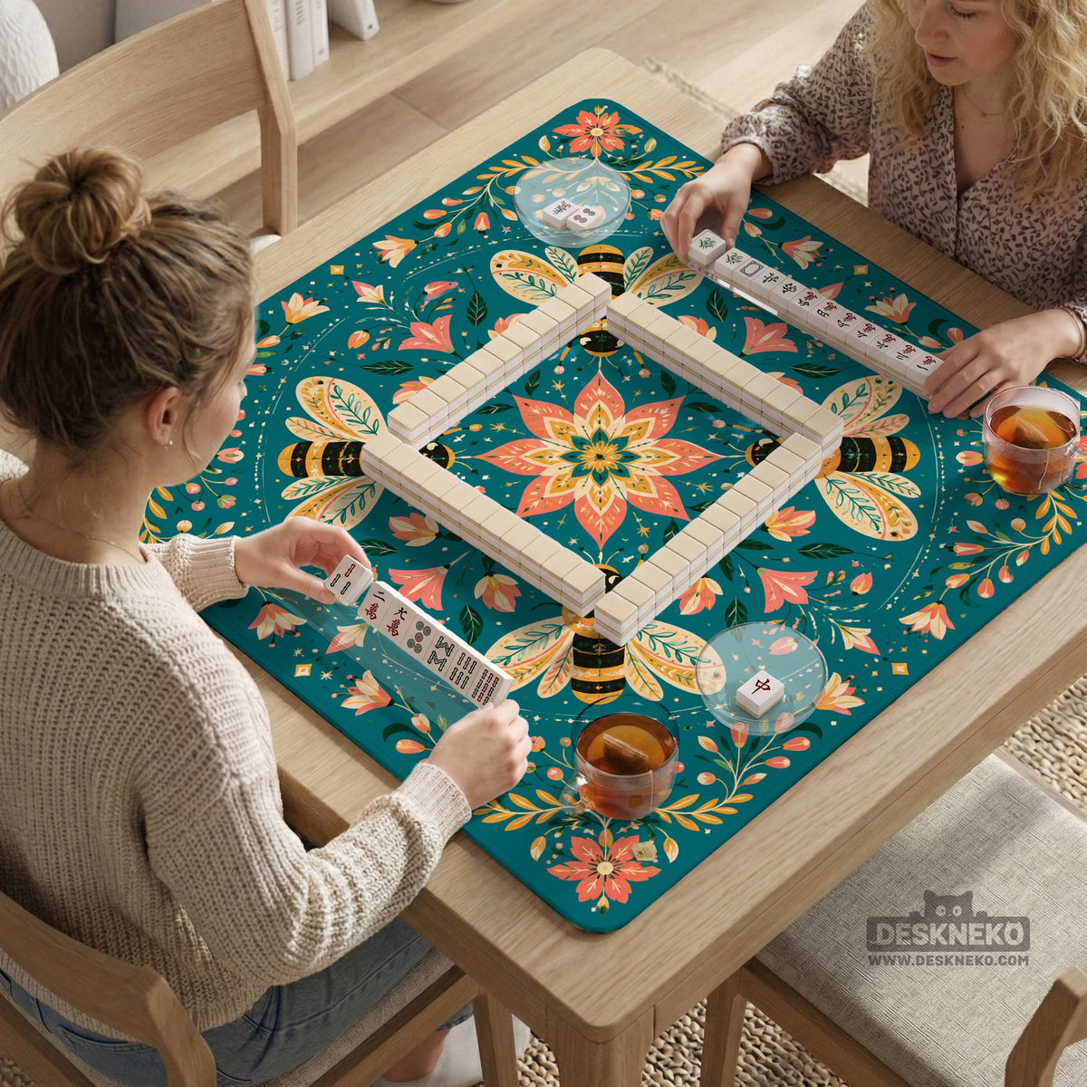 Green mahjong mat with a botanical bee and floral mandala design in teal, coral, cream, and gold.