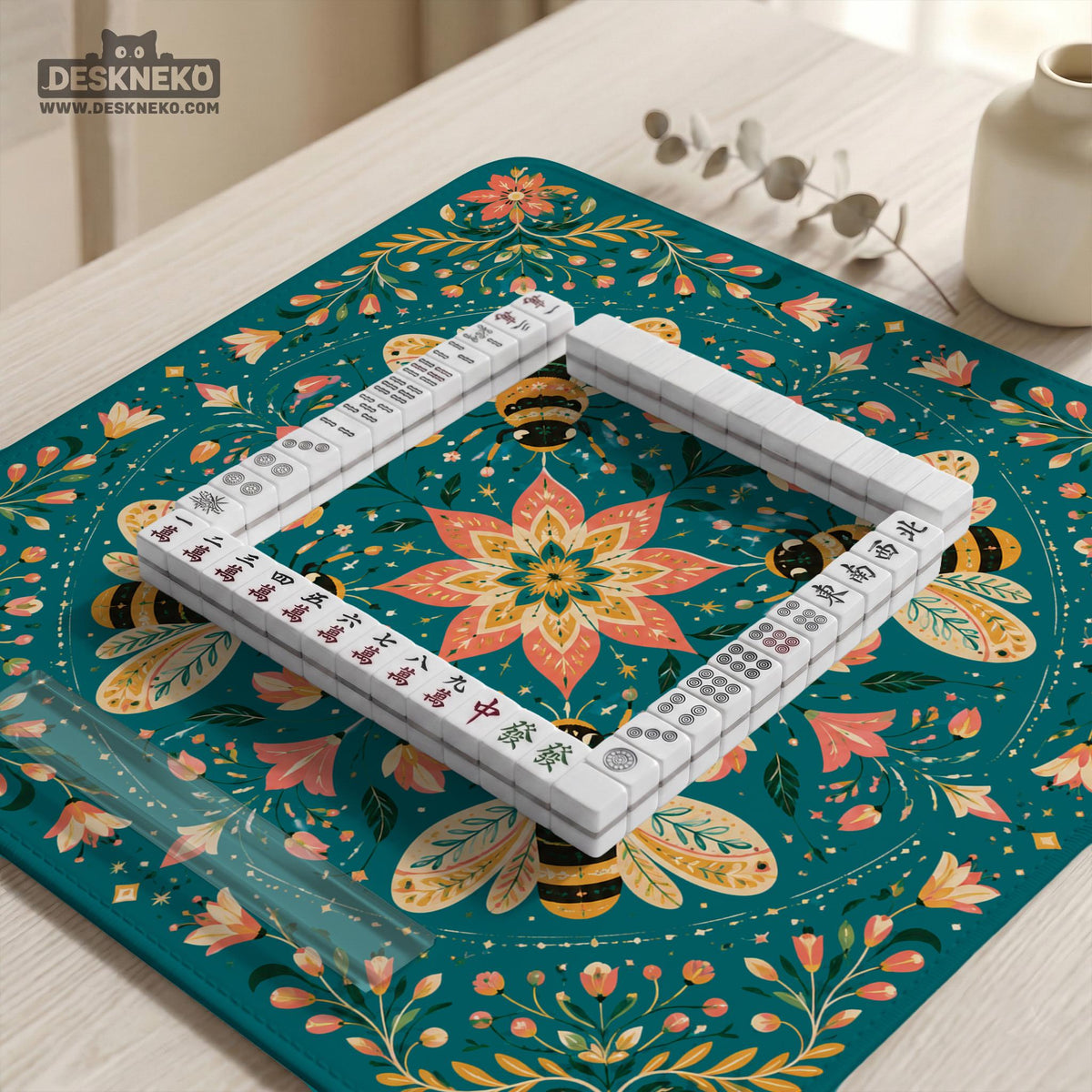 Green mahjong mat with a botanical bee and floral mandala design in teal, coral, cream, and gold.