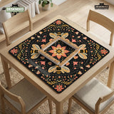 Black mahjong mat with a symmetrical botanical design, coral flowers, golden leaves, and small bees.
