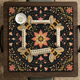 Black mahjong mat with a symmetrical botanical design, coral flowers, golden leaves, and small bees.