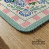 Pastel mahjong mat with a pink gingham border, seashells, hydrangea pots, palm trees, croquet details, and a coastal garden scene.