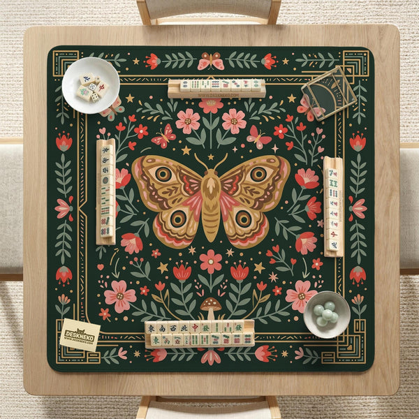 Dark green square mahjong mat with floral branches, small red blossoms, gold line details, and a large moth in the center.