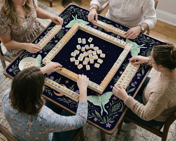 Navy square mahjong mat with a floral border, copper moons, scattered stars, pale moths, and leafy botanical details.