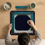 Navy square mahjong mat with a floral border, copper moons, scattered stars, pale moths, and leafy botanical details.