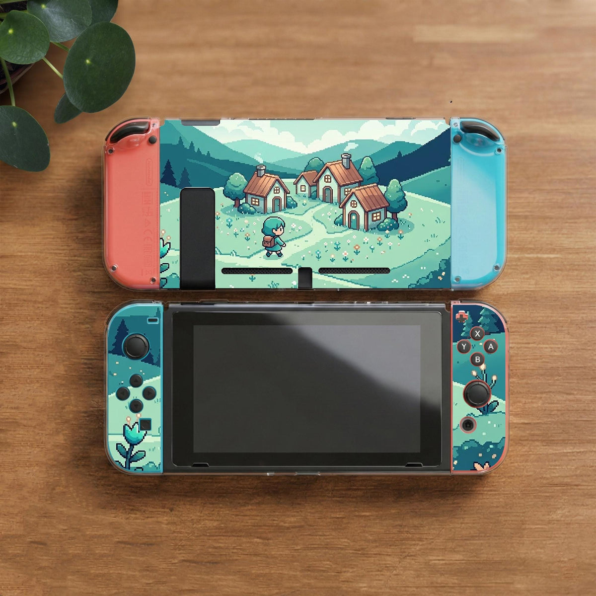 Teal carrying case with a pixel-style village scene, small houses, layered mountains, flowers, and a retro game-inspired landscape design.