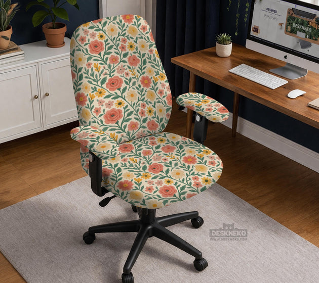 Cream desk chair cover with a vintage floral print featuring coral roses, mustard daisies, and green vines on a chair.