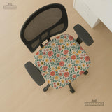 Cream desk chair cover with a vintage floral print featuring coral roses, mustard daisies, and green vines on a chair.