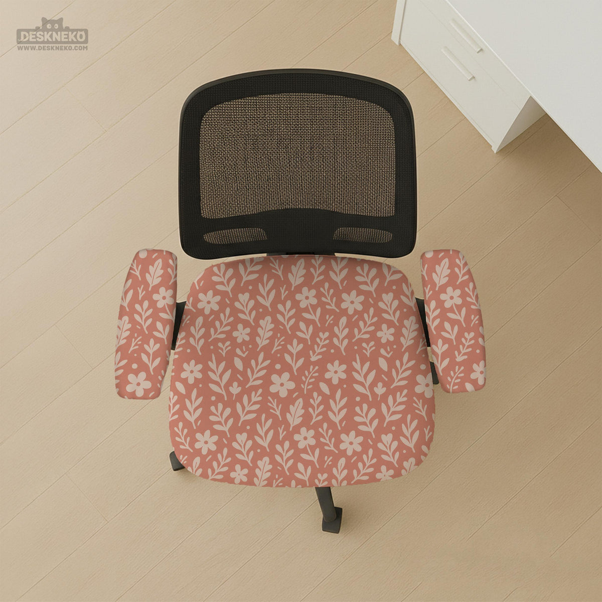 Pink chair cover with a botanical floral print shown on an office chair, with matching armrest covers and multiple cover style options.
