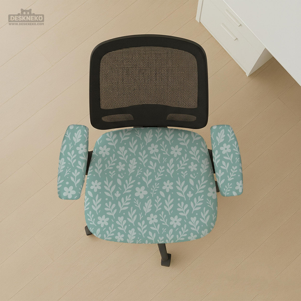 Mint and white botanical desk chair cover with a floral leaf pattern shown on an office chair.