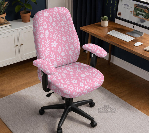 Soft pink floral chair cover shown on a gaming chair with a high back and armrests.