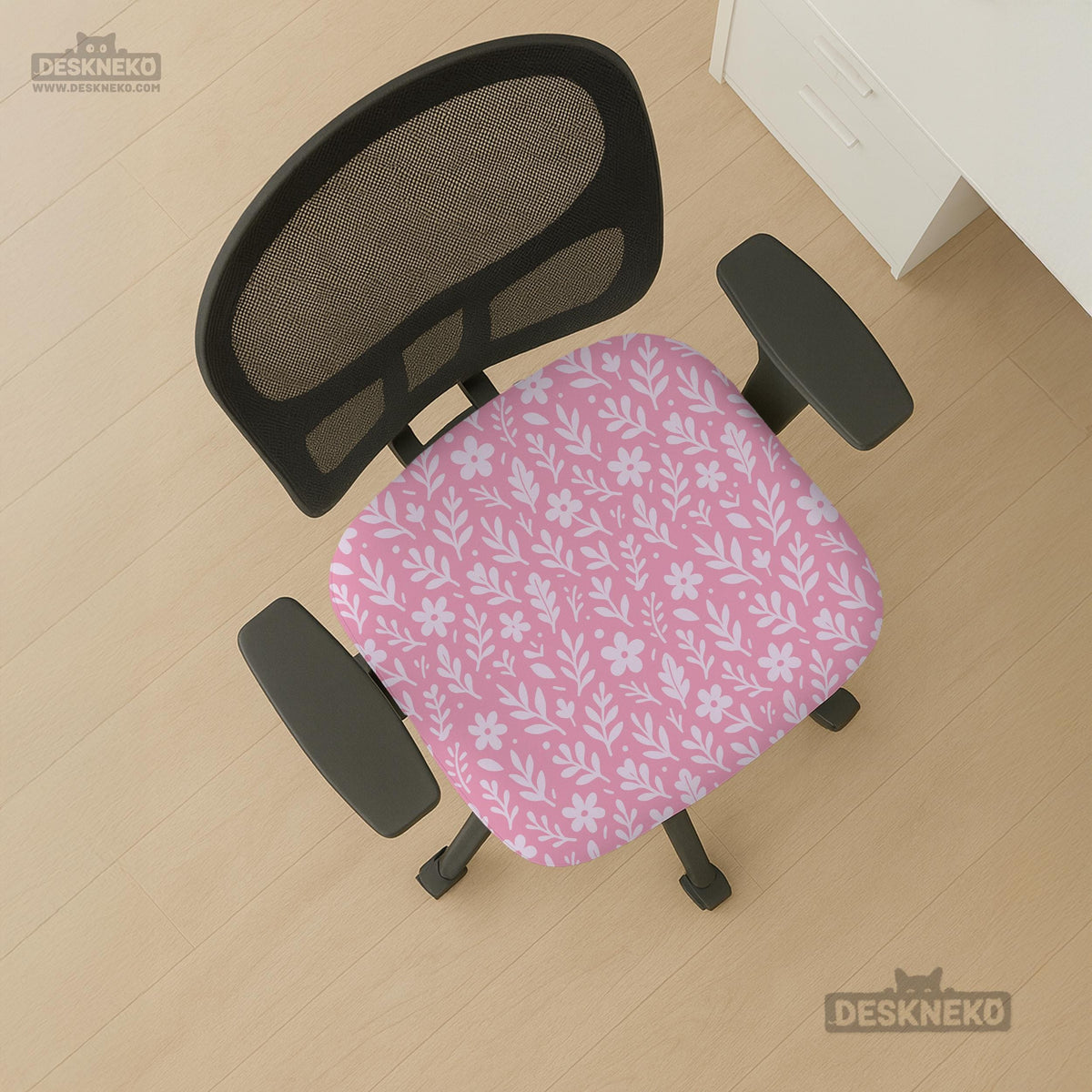 Blush pink chair cover with a small botanical floral pattern shown on an office chair.
