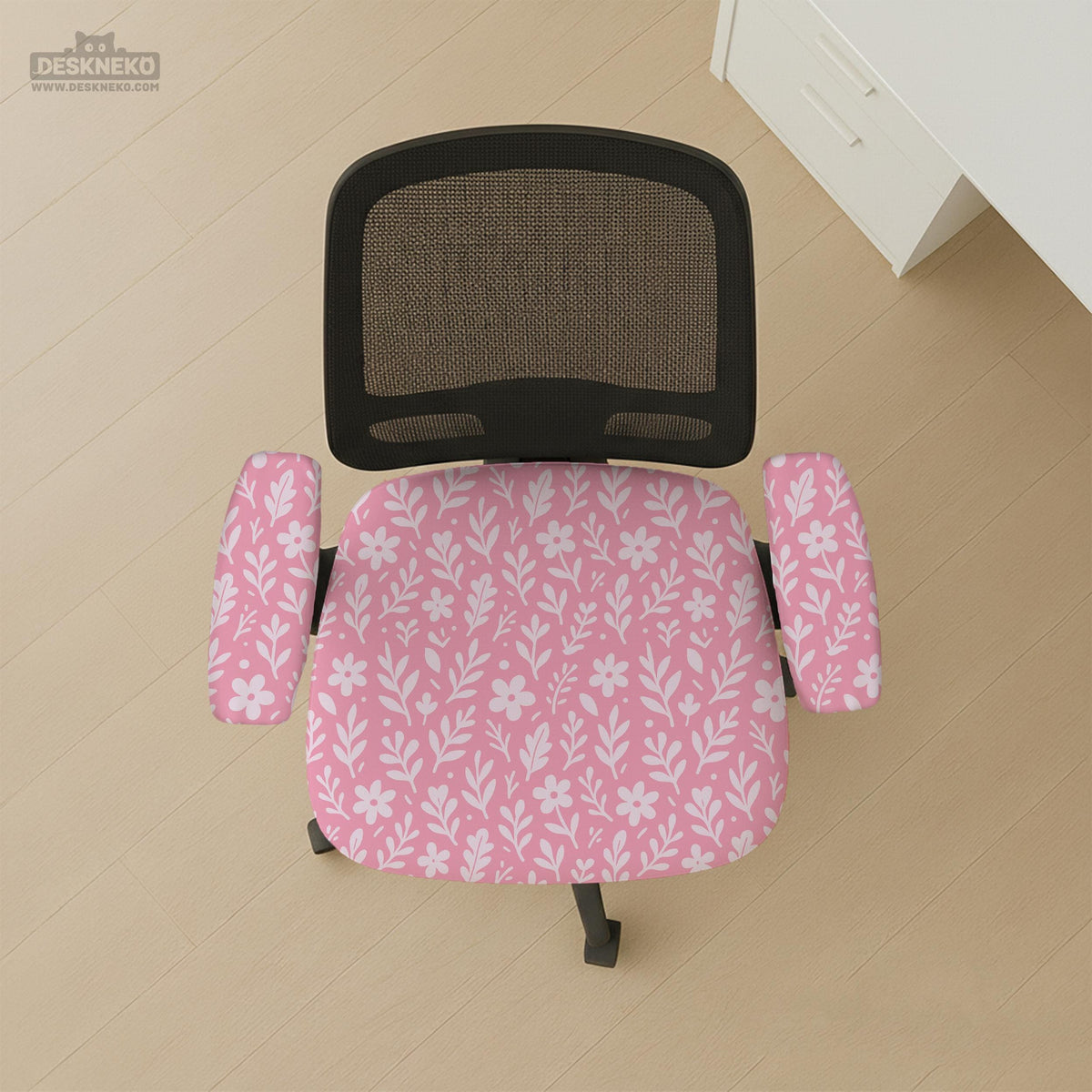 Blush pink chair cover with a small botanical floral pattern shown on an office chair.