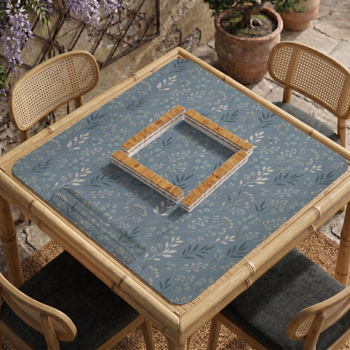 Blue mahjong mat with a dusty linen-look background and small leafy botanical stems in a floral pattern.