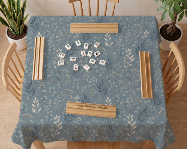 Blue mahjong mat with a dusty linen-look background and small leafy botanical stems in a floral pattern.