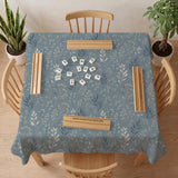 Blue mahjong mat with a dusty linen-look background and small leafy botanical stems in a floral pattern.