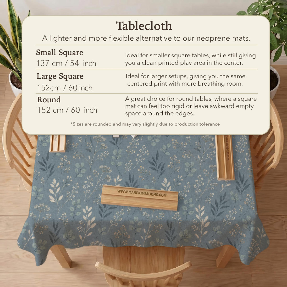 Blue mahjong mat with a botanical floral pattern, pale leaves, and delicate stems on a dusty blue background.