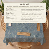 Blue mahjong mat with a botanical floral pattern, pale leaves, and delicate stems on a dusty blue background.