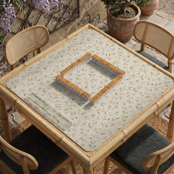 Sage green botanical mahjong mat with a cream background, trailing vines, and muted leaf designs.