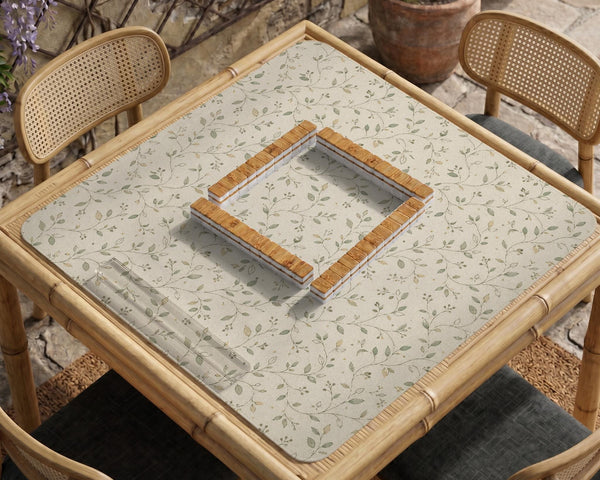 Cream square mahjong mat with a sage vine and leaf botanical pattern and scalloped edges.