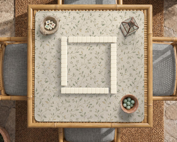 Sage green botanical mahjong mat with a cream background, trailing vines, and muted leaf designs.