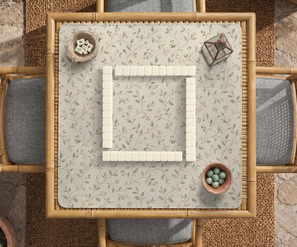 Sage green botanical mahjong mat with a cream background, trailing vines, and muted leaf designs.