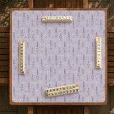 Lavender mahjong mat with a pale purple background, small botanical sprigs, and fine grid lines.