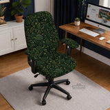 Forest green chair cover with a tropical leaf pattern featuring monstera leaves and small cream flowers.