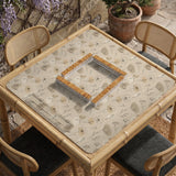 Neutral floral mahjong mat with delicate botanical line art and a scalloped edge on a cream background.