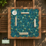 A teal mahjong mat with a peacock feather pattern and scalloped edges.