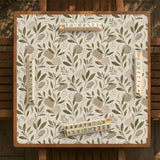 Green botanical mahjong mat with sage leaf and floral design and a scalloped edge.