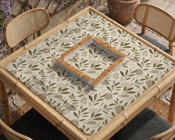 Green botanical mahjong mat with sage leaf and floral design and a scalloped edge.