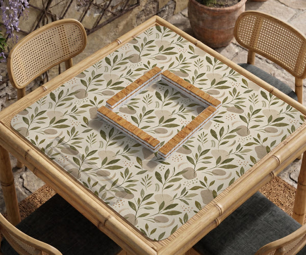 Green botanical mahjong mat with sage leaf and floral design and a scalloped edge.