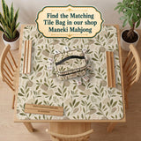 Green botanical mahjong mat with sage leaf and floral design and a scalloped edge.