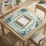 Teal square mahjong mat with peacock feathers, soft floral pattern, tassel details, and printed rule guide text in the center.