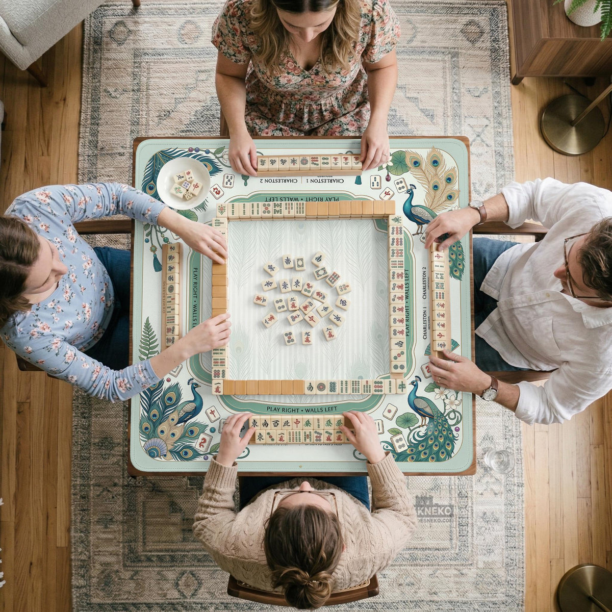 Teal square mahjong mat with peacock feathers, soft floral pattern, tassel details, and printed rule guide text in the center.