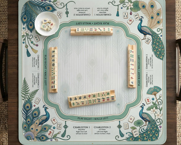 Teal square mahjong mat with peacock feathers, soft floral pattern, tassel details, and printed rule guide text in the center.