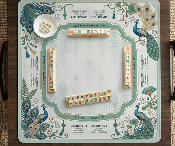 Teal square mahjong mat with peacock feathers, soft floral pattern, tassel details, and printed rule guide text in the center.