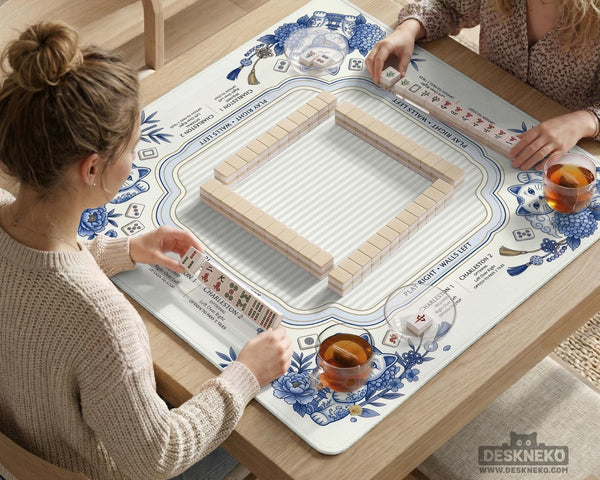 Blue and white square mahjong mat with lucky cat artwork, floral chinoiserie pattern, tile icons, and a rule guide layout.