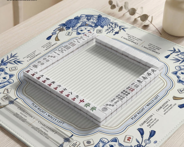 Blue and white square mahjong mat with lucky cat artwork, floral chinoiserie pattern, tile icons, and a rule guide layout.