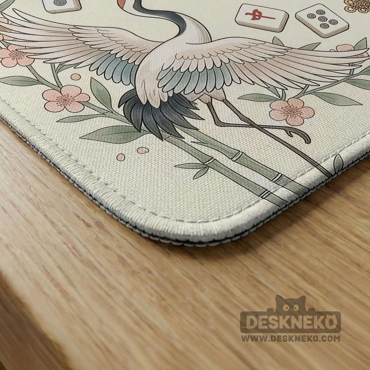 Beige square mahjong mat with a sage border, crane birds, bamboo, flowers, tile icons, and printed rules around a clean center play area.
