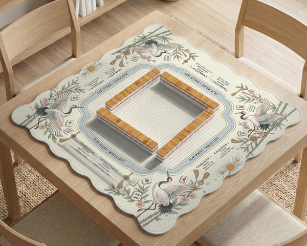 Beige square mahjong mat with a sage border, crane birds, bamboo, flowers, tile icons, and printed rules around a clean center play area.