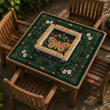 Dark botanical mahjong table mat with a floral border, large moth and butterfly design in the center, gold corner frame, and printed rules layout around the edge.