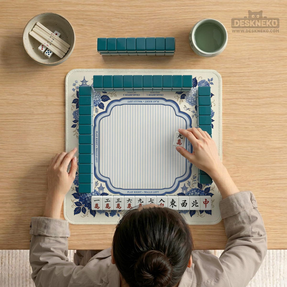 Blue and white mahjong table mat with a floral border, small birds, pagoda details, striped center, and printed rules around the edge.