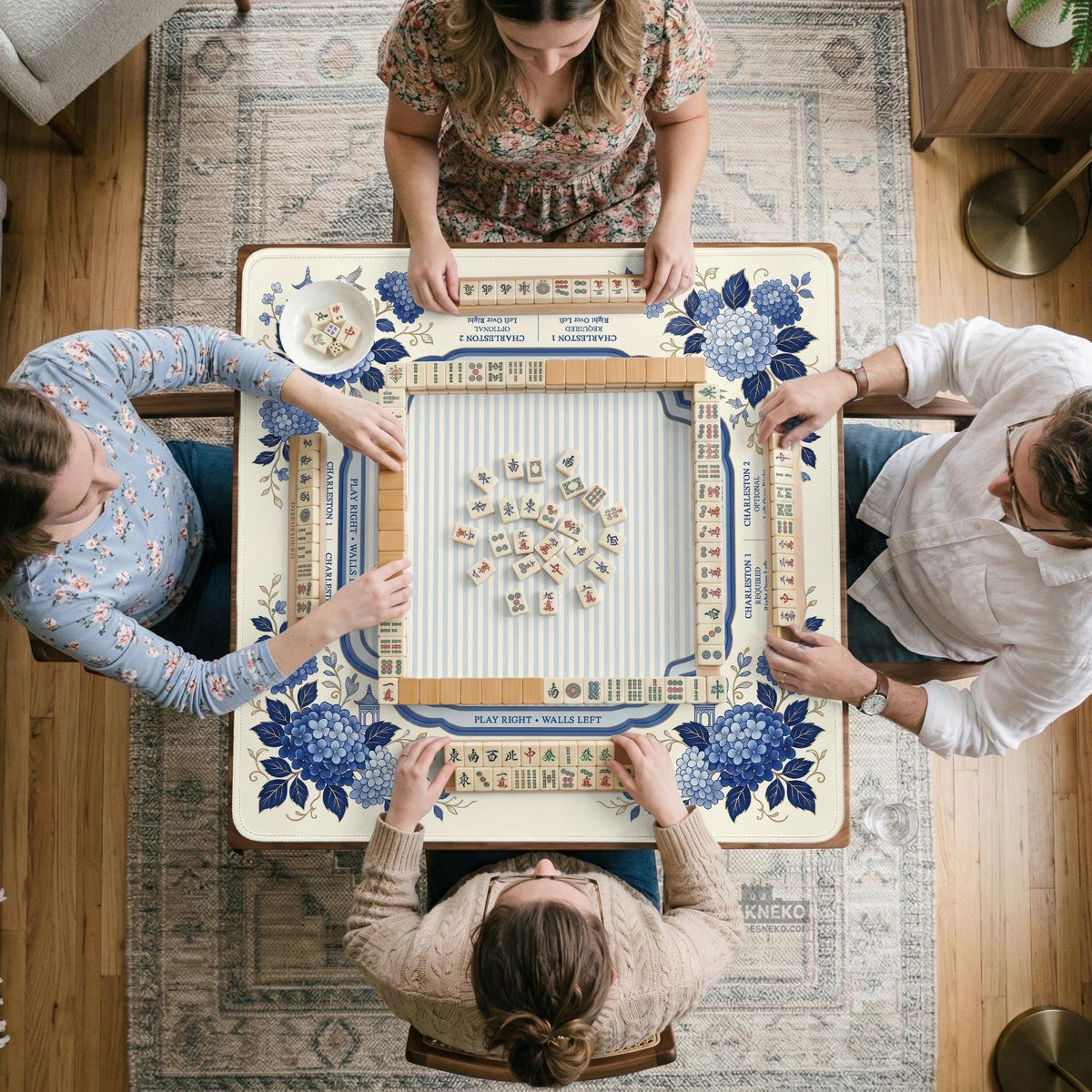 Blue and white mahjong table mat with a floral border, small birds, pagoda details, striped center, and printed rules around the edge.