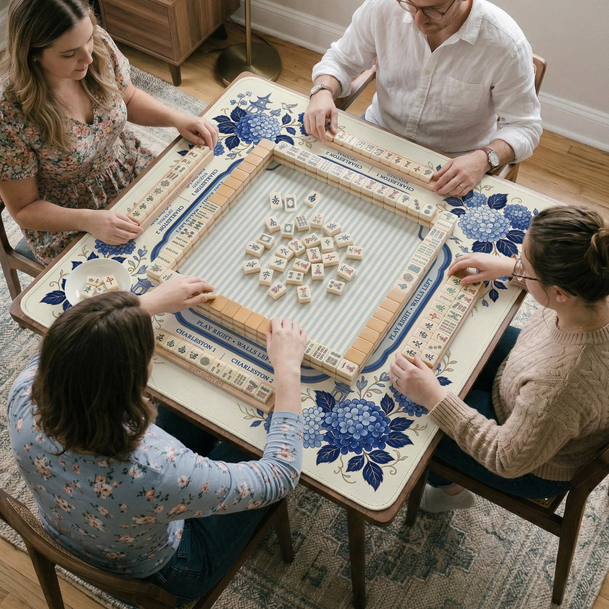Blue and white mahjong table mat with a floral border, small birds, pagoda details, striped center, and printed rules around the edge.