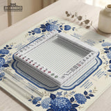 Blue and white mahjong table mat with a floral border, small birds, pagoda details, striped center, and printed rules around the edge.