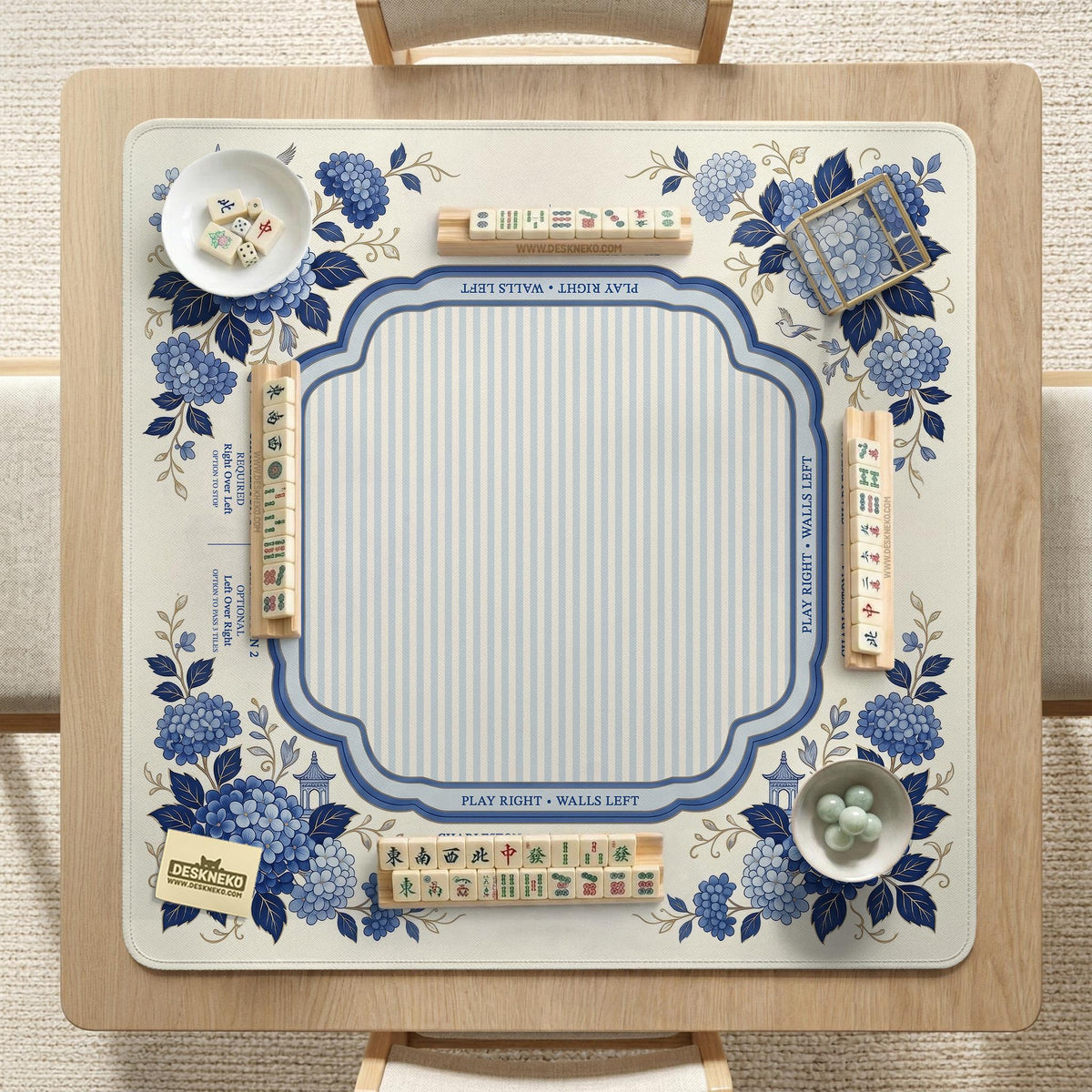 Blue and white mahjong table mat with a floral border, small birds, pagoda details, striped center, and printed rules around the edge.