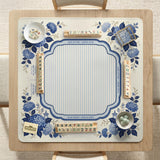 Blue and white mahjong table mat with a floral border, small birds, pagoda details, striped center, and printed rules around the edge.