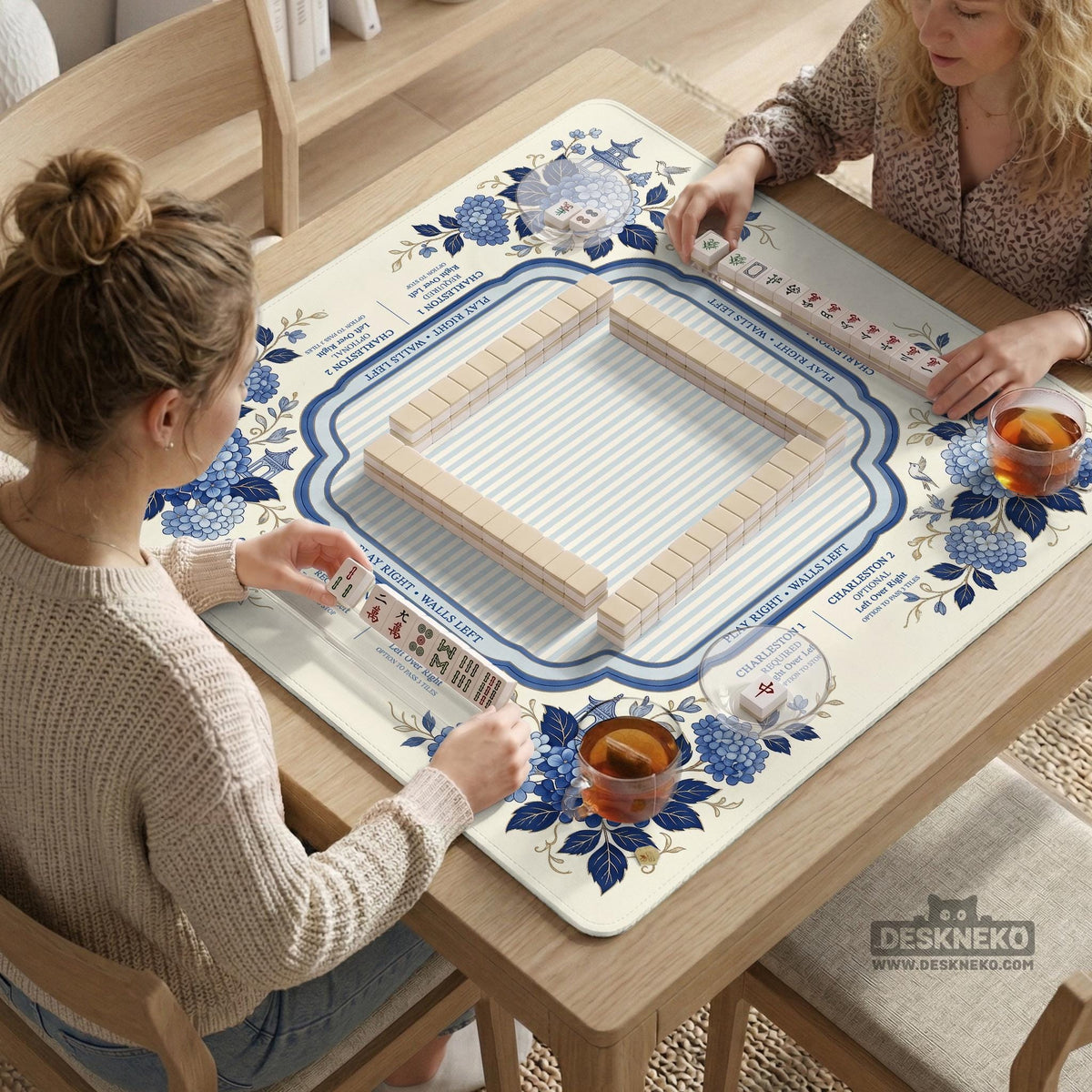 Blue and white mahjong table mat with a floral border, small birds, pagoda details, striped center, and printed rules around the edge.